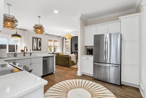A modern kitchen with white cabinetry, stainless steel appliances, and a central island. - Downtown Wilmington | Walk to Riverwalk & Live Oak (Wilmington)