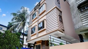 A hotel with a modern facade, multiple windows, and a sign indicating it is a hotel. - Deluxe Lalganesh Formally Royal Avenue (Guwahati)