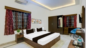 A hotel room with a bed, a desk, a chair, a wardrobe, and a TV. - Single Room Madiwala Lake Park (Bengaluru)