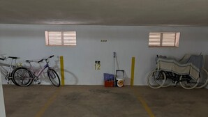 Een parkeergarage met twee fietsen, een rolstoel en een emmer verf.