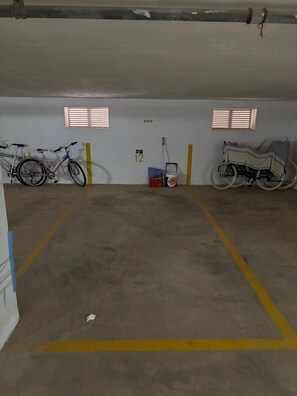 A parking garage with two bicycles, a wheelchair, and a bucket of paint. - Vacation apartment just 100m from the beach -Vacation apartment just 100m from the Beach (San Pedro del Pinatar)