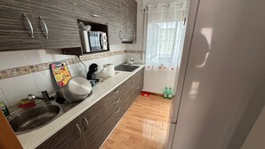 Een keuken met een spoelbak, fornuis en kastjes.