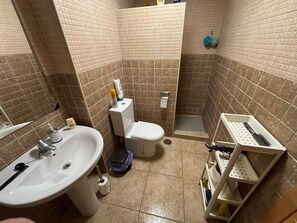 A bathroom with a sink, toilet, shower, and storage shelves. - Vacation Apartment 100 Meters from the Beach - Vacation Apartment 100 Meters from the Beach (San Pedro del Pinatar)