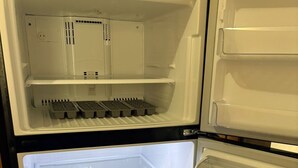 Un réfrigérateur doté de plusieurs compartiments, notamment un congélateur, un compartiment principal et une étagère sur la porte.