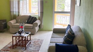 Ein Wohnzimmer mit zwei Sofas, einem Couchtisch und einem Fenster mit Blick.