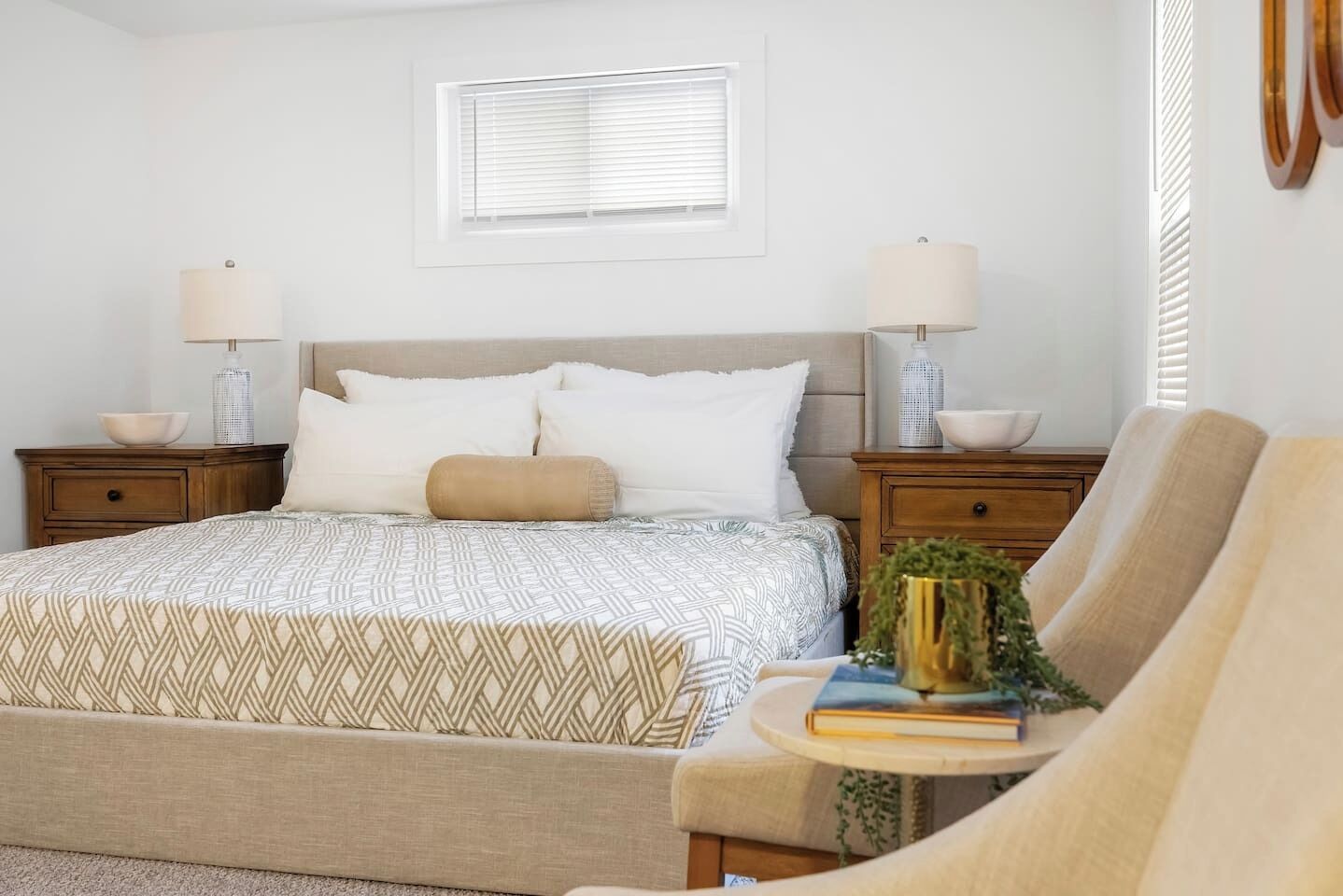 A bedroom with a bed, bedside tables, a lamp, a chair, and a window.