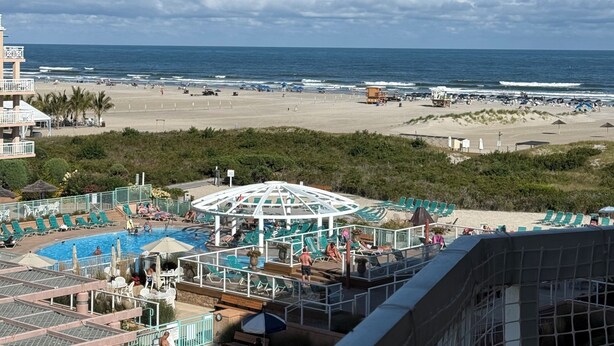 Um resort com área de piscina, acesso à praia e vista para o oceano.