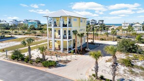 A multi-story building with a balcony, surrounded by palm trees and a beach view. - Brand new home offering spectacular amenities with gorgeous sunrises and sunsets (Port St. Joe)