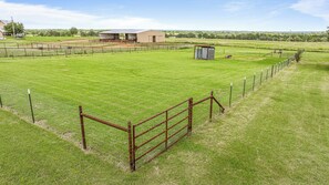A fenced property with a barn, open fields, and a small shed. - Crooked F Ranch - Sleeps 6, Horse Friendly, Located 2.6 Miles from 377 Arena (Stephenville)