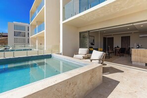 A modern hotel with a pool, outdoor seating, and a view of the surrounding area. - Cabo Retreat w/ Private Pool & Sea Views (Cabo San Lucas)