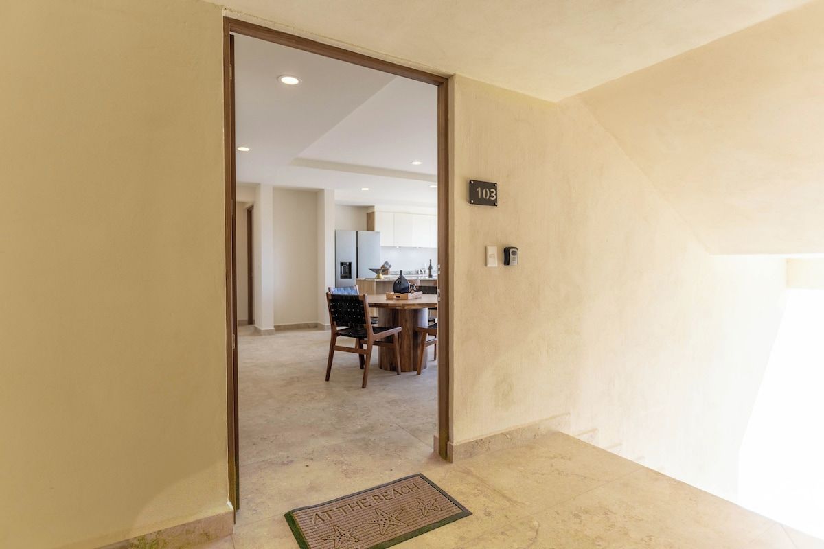 A hallway with a door leading to a dining area.