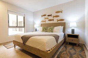 A bedroom with a wooden bed, a wall-mounted fish decoration, a bedside lamp, and a patterned rug. - Cabo Retreat w/ Private Pool & Sea Views (Cabo San Lucas)