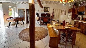 A spacious kitchen with a dining area, wooden furniture, and a ceiling with exposed beams. - Drôme provençale house with swimming pool and river (La Bégude-de-Mazenc)