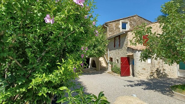A stone building with a red door, a small window, and a gravel path leading to it. - Drôme provençale house with swimming pool and river (La Bégude-de-Mazenc)