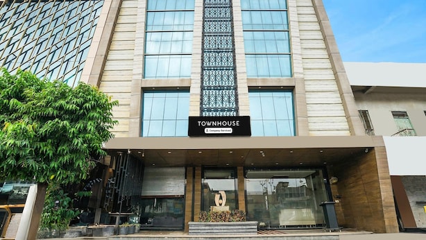 A modern building with a sign reading "TOWNHOUSE" and a company-serviced logo.
