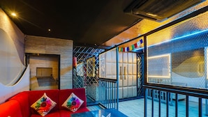 A modern interior with a red sofa, a black table, and a patterned wall.