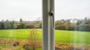 A window with a view of a green field and distant buildings. - Coventry House Near City Centre & Arena (Coventry)