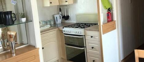 A compact kitchen with a gas stove, oven, and a small countertop area.
