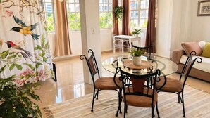 A spacious room with a dining table, chairs, a sofa, and large windows. - Bright & Spacious Apartment in Obarrio | Walk to Everything + City Views (Panamá)