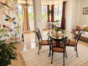 A spacious room with a dining table, chairs, a sofa, and large windows. - Bright & Spacious Apartment in Obarrio | Walk to Everything + City Views (Panamá)