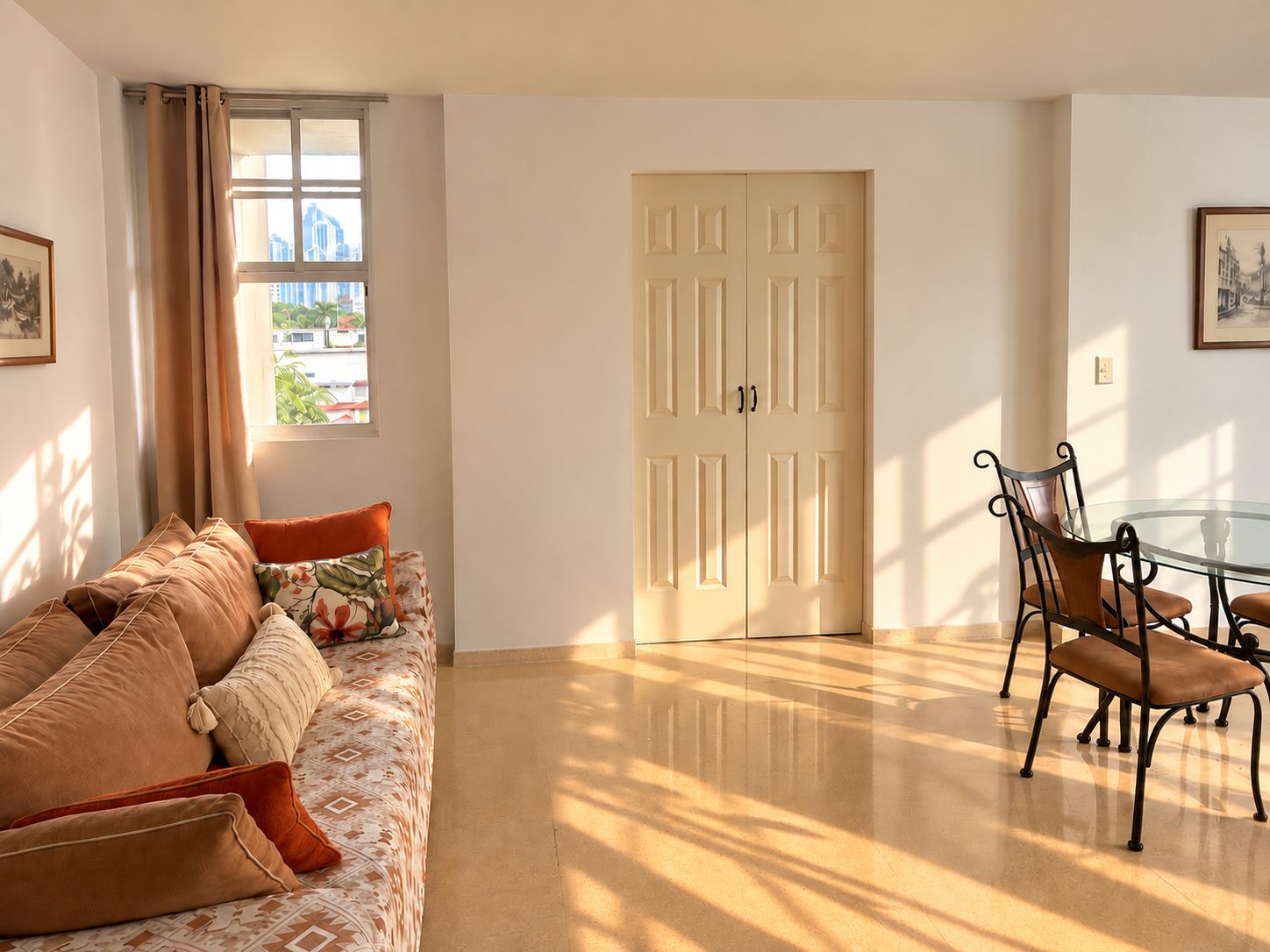 Une pièce comprenant un canapé, une table à manger avec des chaises, une porte et une fenêtre avec des rideaux.
