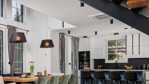 A modern interior with a staircase, dining area, kitchen, and seating. - Holiday House Gorski kotar / Silver House Mrkopalj (Mrkopalj)
