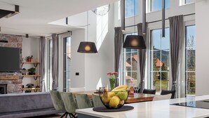 A modern kitchen with a central island, pendant lights, and a view to the outside. - Holiday House Gorski kotar / Silver House Mrkopalj (Mrkopalj)