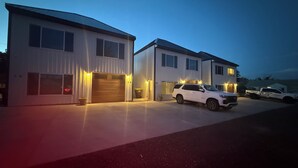 Ein modernes, zweistöckiges Haus mit Garage, Auffahrt und geparktem SUV.