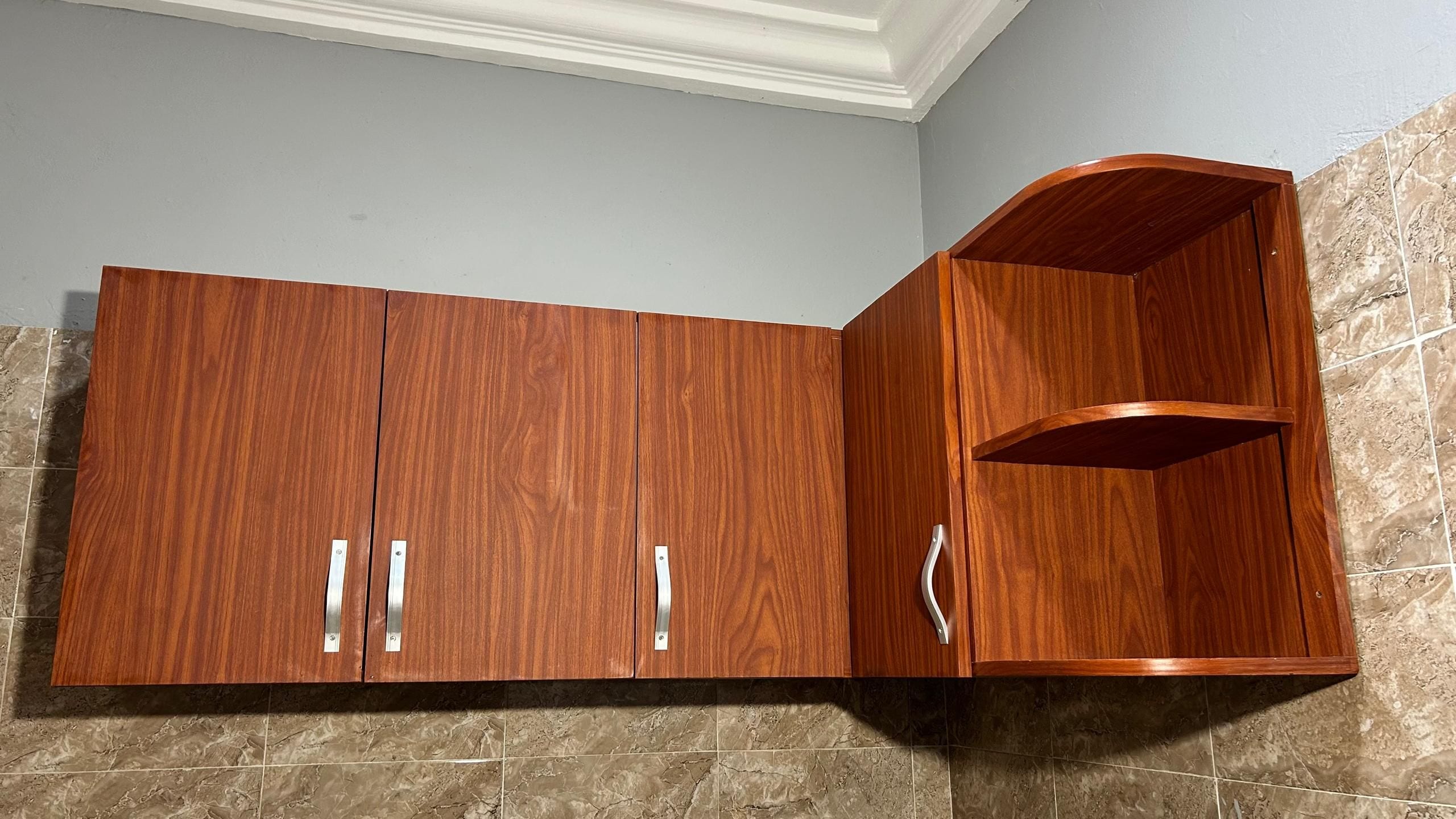 Un armario de madera con dos puertas y un estante curvo.