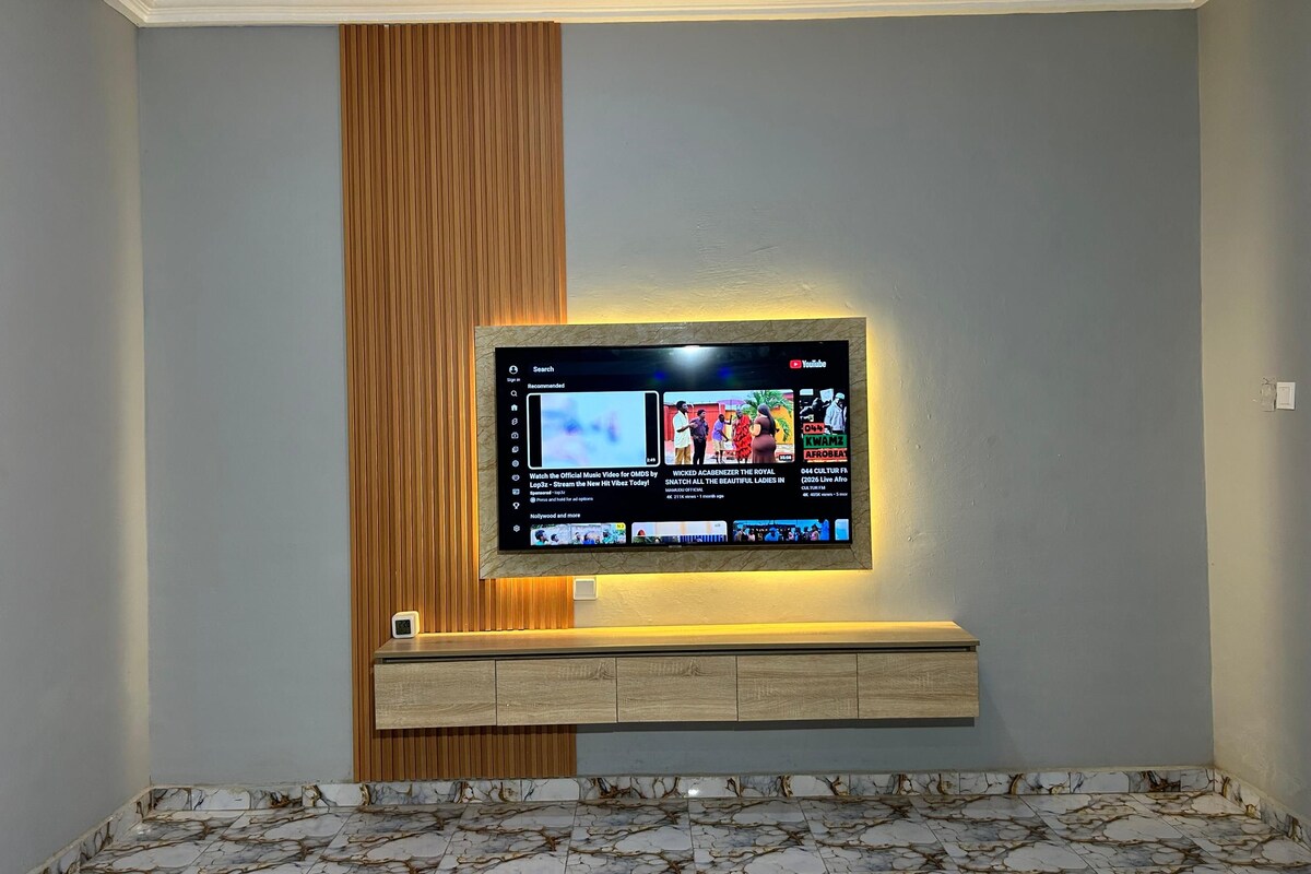 Ein Flachbildfernseher an einer Wand mit Holzpaneelen und einem Marmorboden.