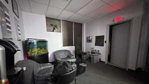 A room with a desk, a chair, a fish tank, a door, and a plant. - Production Studio - 4 Sets / 2 Offices / Light Bank / Hex Lighting  - 4k SF (West Babylon)