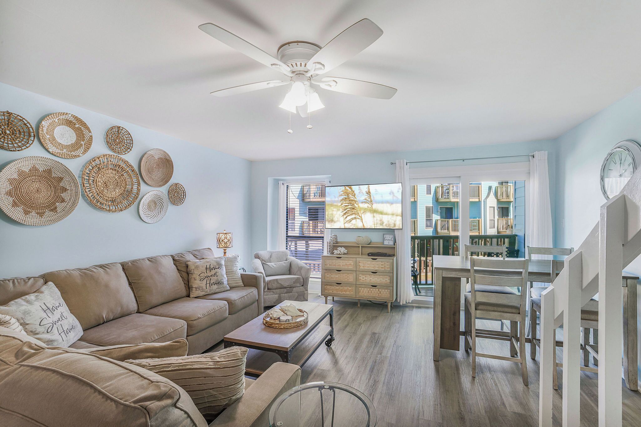 A living room with a sofa, coffee table, and a dining area with chairs and a table.
