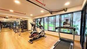 A gym with exercise equipment, a treadmill, and large windows with a view. - Apartamento Moderno em Edifício de Luxo - 3 beds/3 baths (Miraflores)