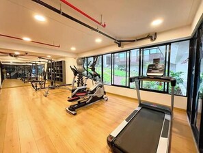 Ein Fitnessstudio mit Trainingsgeräten, Laufband und großen Fenstern mit Blick.