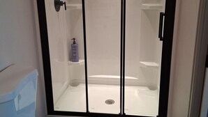 A bathroom with a toilet, a shower enclosure, and a sink. - Comfortable New Studio in Rawlins Wyoming #3B (Rawlins)