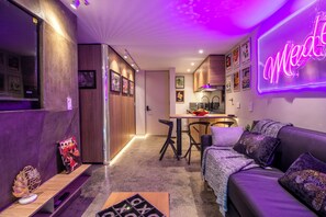 A modern living room with a sofa, a coffee table, and a neon sign. - Ayamonte 306 (Medellín)