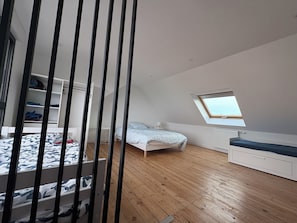 A bedroom with a bunk bed, a skylight, a white wardrobe, and a wooden floor. - Seaside house, walking distance to the beach, sea view (Porspoder)