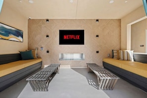 Una sala moderna con un cartel de Netflix, dos sofás y una chimenea.
