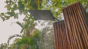 Un jardín con una estructura de madera y una fuente de agua.