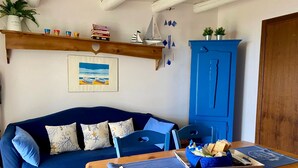 Une pièce chaleureuse avec un canapé bleu, une table en bois et un meuble bleu.
