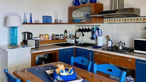 Une cuisine avec des chaises bleues, une table en bois et un poêle.