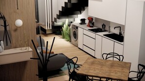 A modern kitchen with a sink, stove, and coffee maker. There is a dining area with a table and chairs. - Waterfront Apartment in San Leone with Sea View (San Leone)