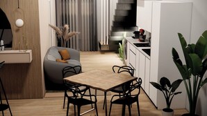 A modern kitchen with a dining area, including a wooden table and chairs, a grey sofa, and a potted plant. - Waterfront Apartment in San Leone with Sea View (San Leone)