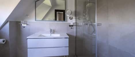 Habitación doble Deluxe, vista al jardĆn | BaƱo | Regadera, secadora de cabello, pantuflas, toallas
