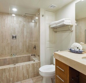 Ein Badezimmer mit Dusche, Toilette und Waschtisch mit Handtuchhalter.