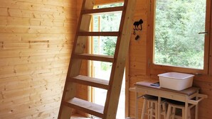 Un interno in legno con una scala in legno, una finestra e un lavandino.