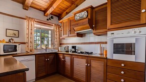 A kitchen with wooden cabinets, a microwave, a dishwasher, a stove, and a refrigerator. - Peaceful Algarve Couple Escape With Pool (Portimão)