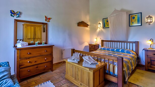 A bedroom with a wooden bed, a wooden dresser, a mirror, and a bedside table with a lamp. - Peaceful Algarve Couple Escape With Pool (Portimão)