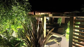A covered outdoor area with a pool, surrounded by dense foliage and a wooden pergola. - Villa 5 bedrooms, Bali style with pool and jacuzzi, land 1700 m², near lake (Ambronay)