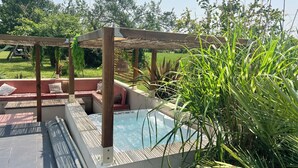 A pool area with a wooden pergola, seating, and surrounding greenery. - Villa 5 bedrooms, Bali style with pool and jacuzzi, land 1700 m², near lake (Ambronay)